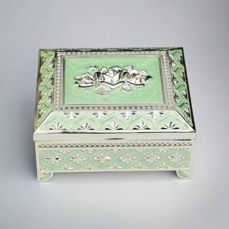 A sea green enamel jewelry box with a floral design on the lid and silver detailing