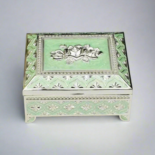 A sea green enamel jewelry box with a floral design on the lid and silver detailing