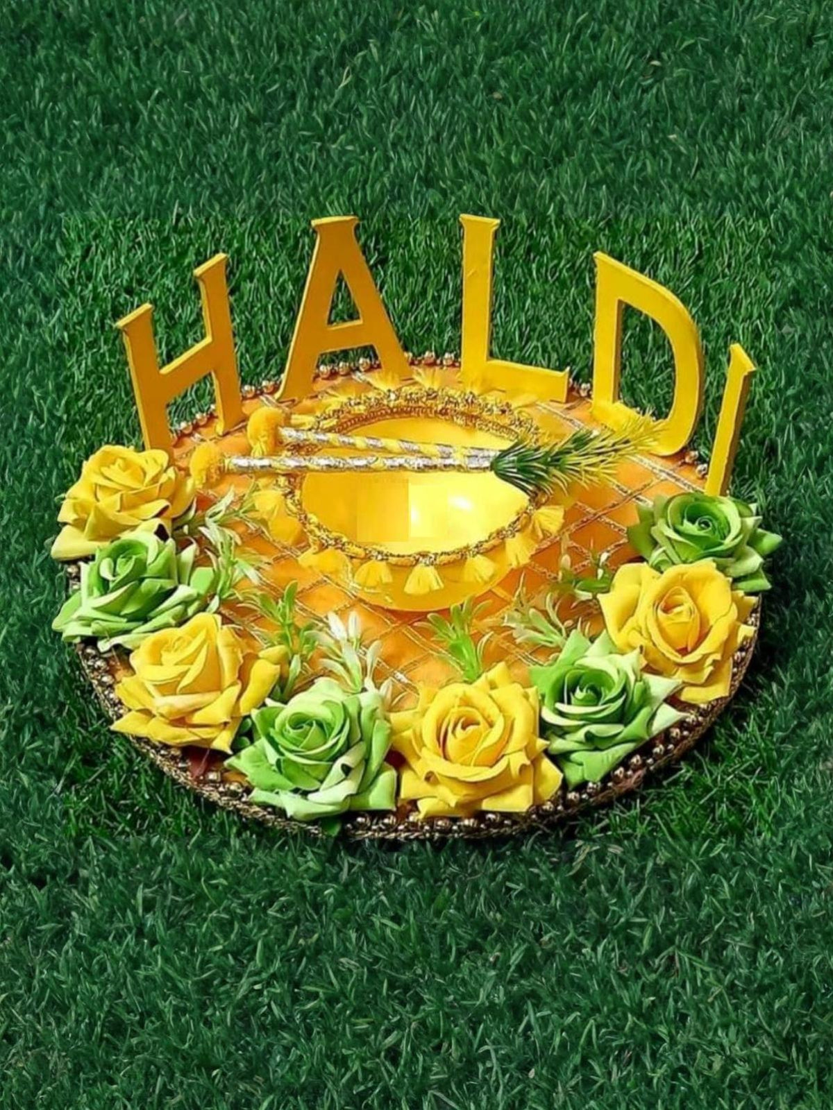 Handmade round Haldi Platter decorated with yellow and green flowers, golden bowl, and decorative sticks for wedding and festive rituals