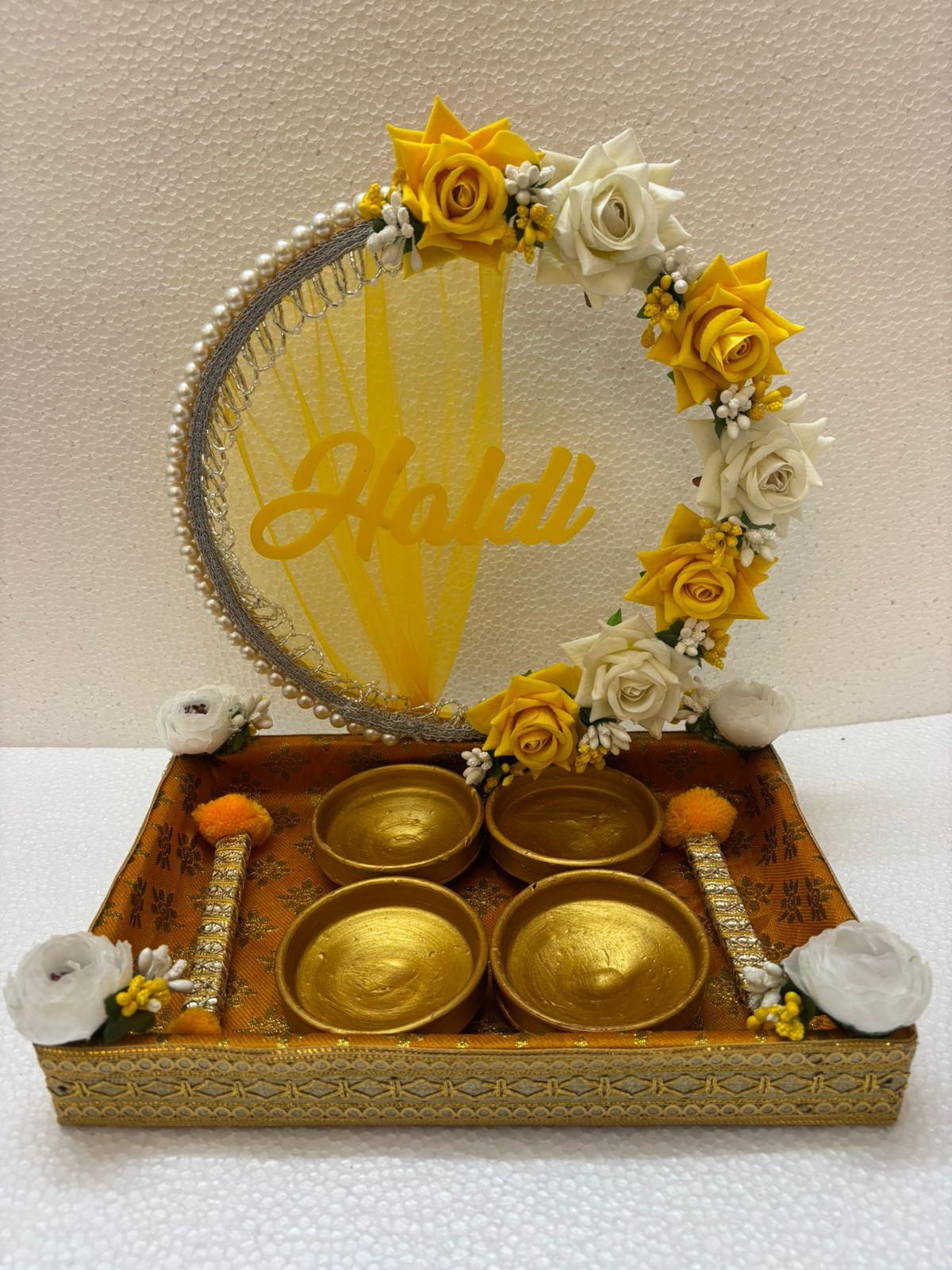 Handmade Haldi Platter with yellow and white flowers, pearl accents, golden bowls, and decorative sticks for wedding and festive rituals