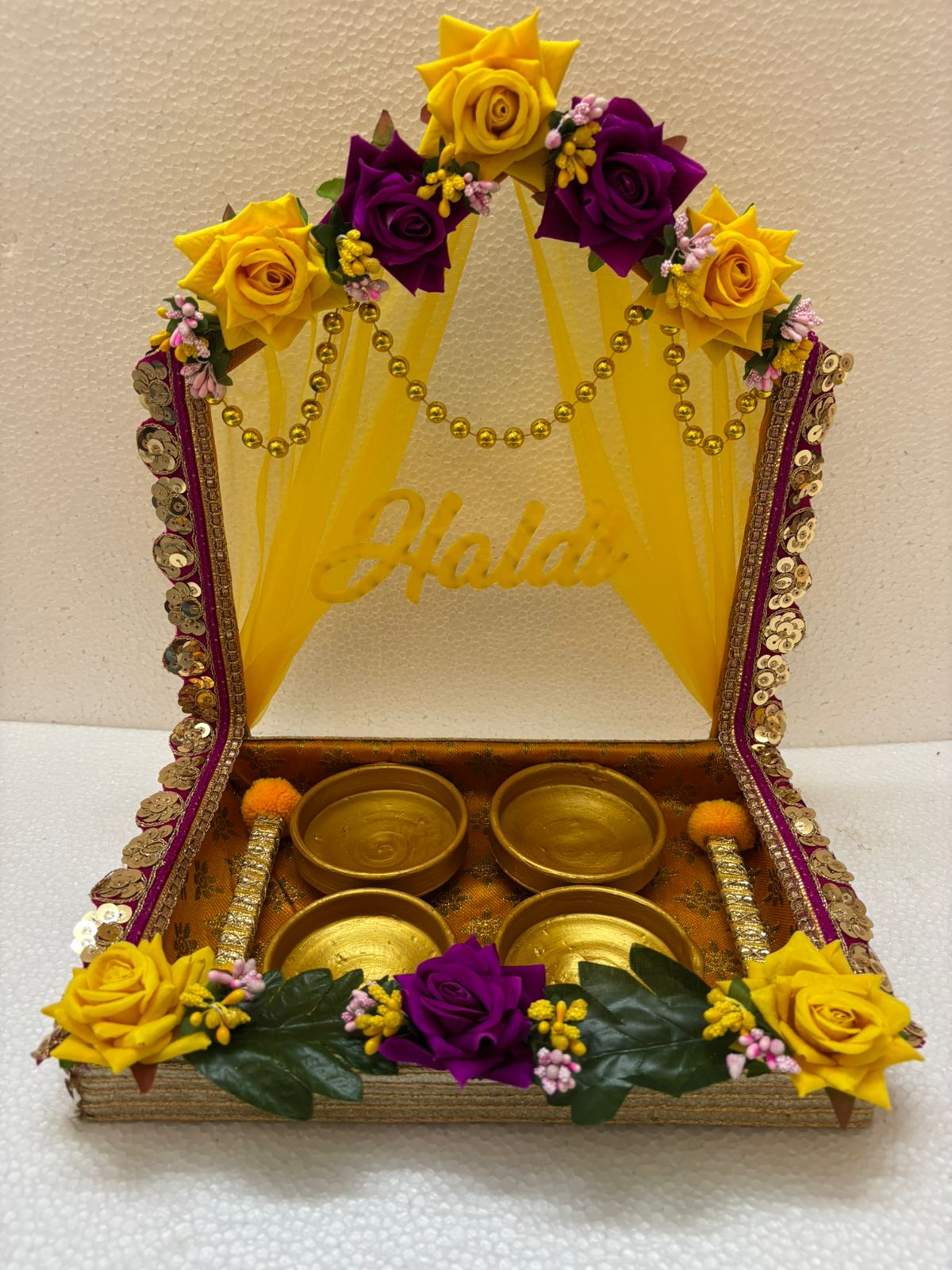 Handmade Haldi Platter decorated with yellow and purple flowers, golden beads, sequins, and four golden bowls for wedding and festive rituals
