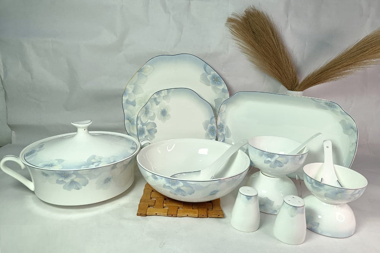 Ceramic dinnerware set with floral patterns on a plain background