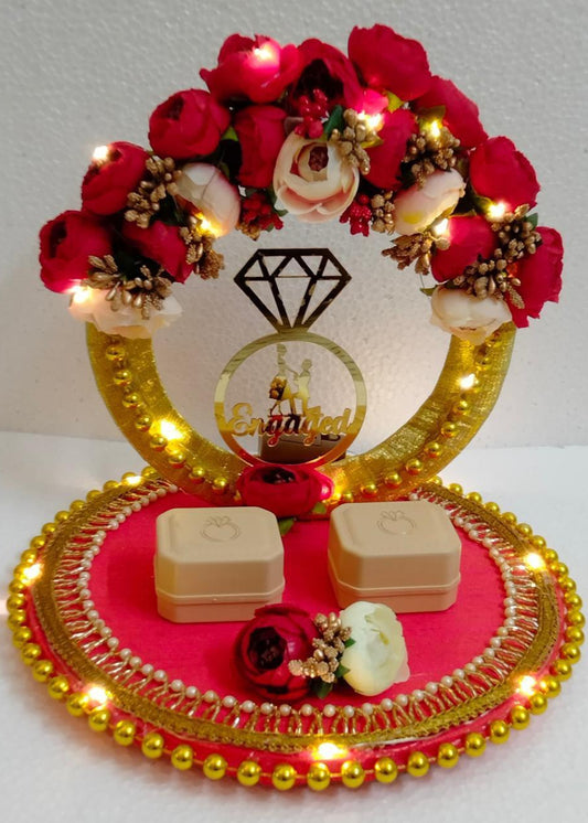 A handmade, artistically designed red and gold ring platter with LED lights, floral decorations, and a central ring holder, intended for ring ceremony purposes.