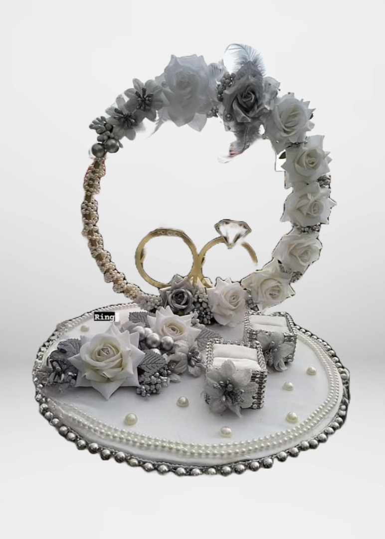 A silver ring platter with floral designs and decorative elements, intended for ring ceremony purposes.